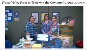 Three members of the team next to their booth containing information about product and promotional material