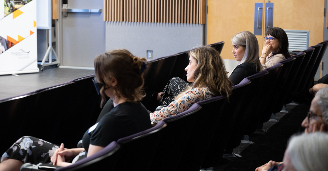 Members of the CHASI team seat at the front of the theatre, excitedly watching the speakers on stage