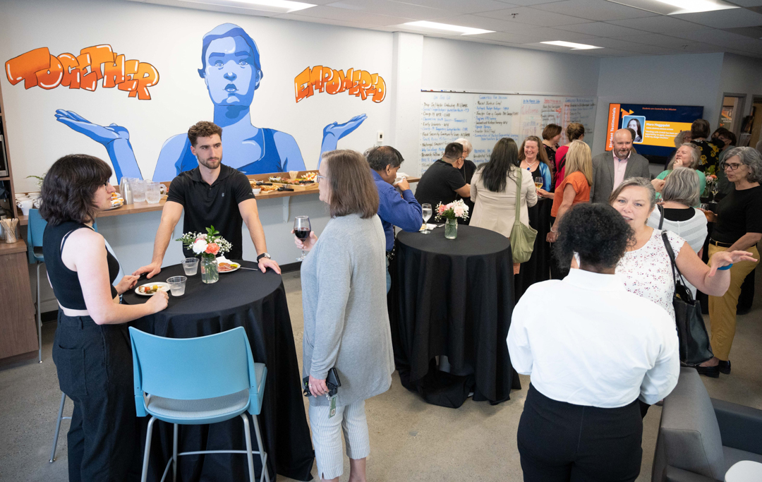 Wide shot of the CHASI hub, filled with chatting and mingling people enjoying wine and snacks