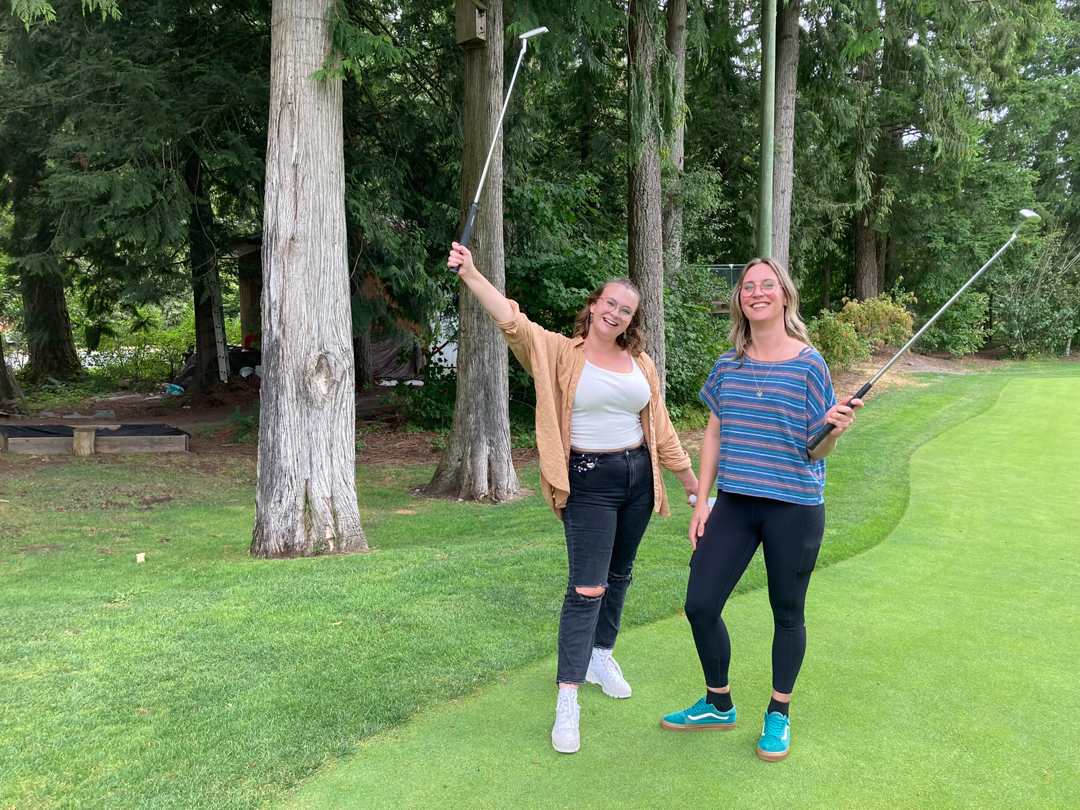 Photo of CHASI research assistants Andrea Moorhouse and Ekat Marenkov posing for a photo with their putters raised in celebration. 