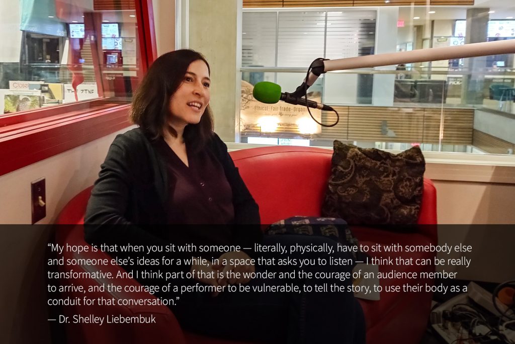 Dr. Shelley Liebembuk sits in the CIVL Radio studio with a microphone in front of her. Behind her, a window looks out at the UFV Abbotsford Student Union Building Atrium. A quote from Dr. Liebembuk reads: “My hope is that when you sit with someone — literally, physically, have to sit with somebody else and someone else’s ideas for a while, in a space that asks you to listen — I think that can be really transformative. And I think part of that is the wonder and the courage of an audience member to arrive, and the courage of a performer to be vulnerable, to tell the story, to use their body as a conduit for that conversation.”