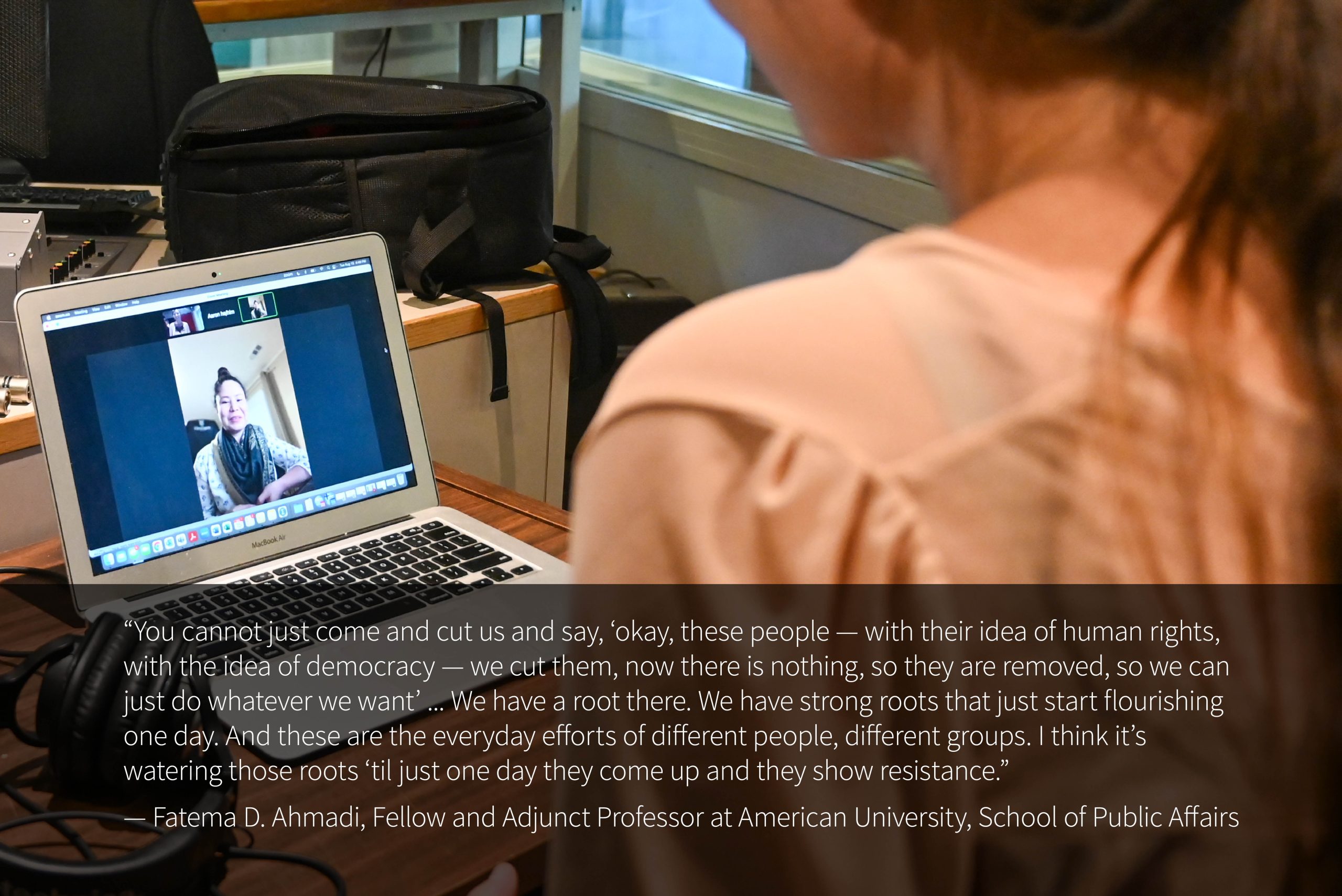 Photo of a laptop Fatema D. Ahmadi on a Zoom video call, taken from over the shoulder of Chelsea Klassen, who is looking at the laptop. A quote reads: "“You cannot just come and cut us and say, ‘okay, these people — with their idea of human rights, with the idea of democracy — we cut them, now there is nothing, so they are removed, so we can just do whatever we want’ ... We have a root there. We have strong roots that just start flourishing one day. And these are the everyday efforts of different people, different groups. I think it’s watering those roots ‘til just one day they come up and they show resistance.” — Fatema D. Ahmadi, Fellow and Adjunct Professor at American University, School of Public Affairs"