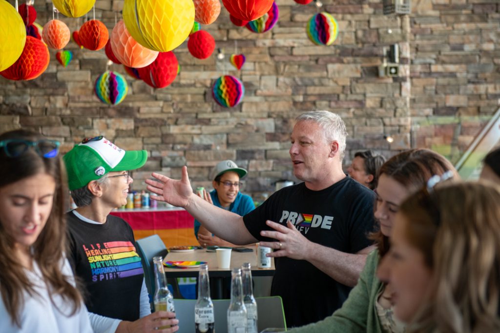 CHASI Director Dr. Martha Dow and UFV President Dr. James Mandigo speak at the Tea Dance, both wearing Pride shirts.