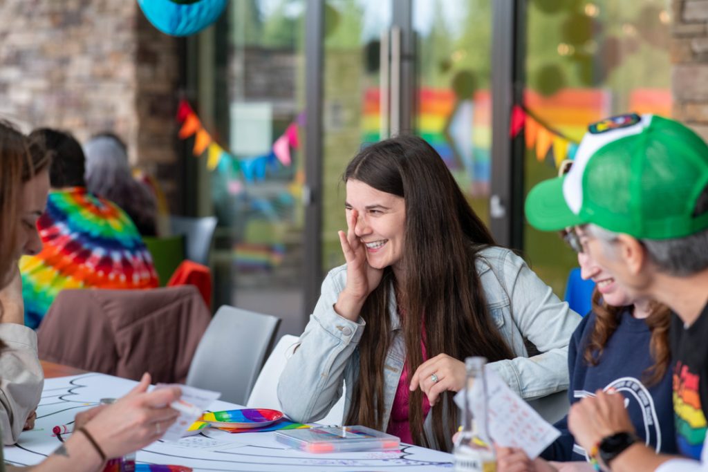 Photo of CHASI lead researcher Chelsea Klassen at the Tea Dance, smiling and laughing surrounded by other people.