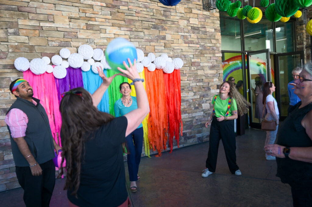 Photo of people at the tea dance in a circle throwing a beach ball between them as they dance.