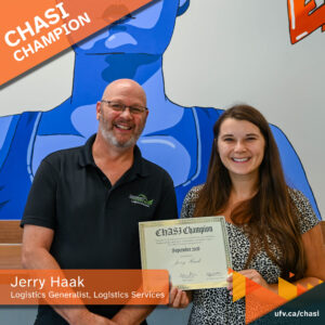 Photo of Jerry Haak and Chelsea Klassen, holding up a certificate that reads "CHASI Champion" and smiling for a photo. Text overlaying the photo reads: "CHASI Champion: Jerry Haak, Logistics Generalist, Logistics Services."