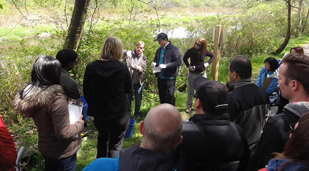 UFV geography instructor Scott Shupe discusses water collection with volunteers, including the president of HSBC Bank of Canada.