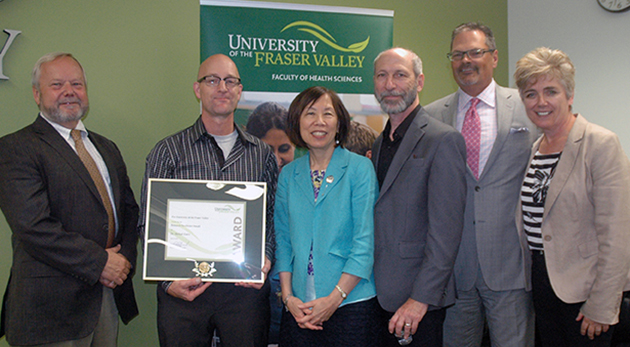 Dr. Michael Gaetz of the Kinesiology and Physical Education department received the UFV Research Excellence award for 2014. Pictured with Gaetz (holding award) are UFV President Mark Evered; Adrienne Chan, Associate VP of Research, Engagement, and Graduate Studies; Provost and VP Academic Eric Davis; UFV Board of Governors Second Vice Chair Randy Bartsch; and Dean of Health Sciences Joanne MacLean.