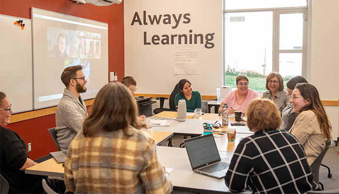 A group of UFV faculty gather around a conference table at the Teaching and Learning Centre