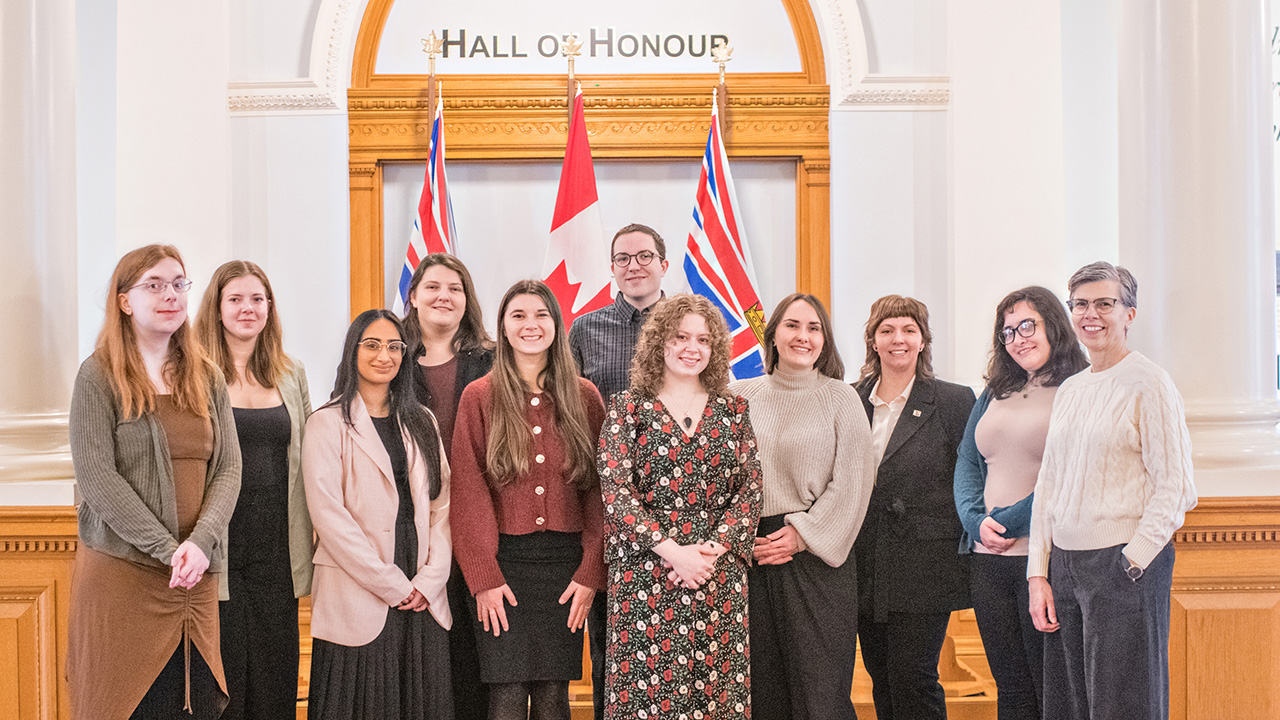 Members of the CHASI team pose in front of flags in the BC Legislature Building