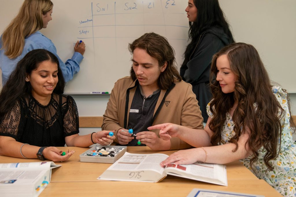 Students looking at atom models.