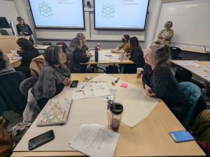 2 people sitting at a table in mid-discussion