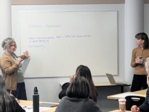 Amea Wilbur and Brianna Strumm standing next to a whiteboard