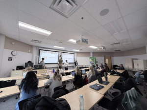 students standing in front of a projector screen in Joys class
