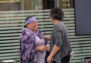 Lorna shaking a womans hand and smiling
