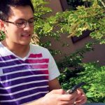 UFV student playing Pokemon GO near Marina Magnone Memorial Tree