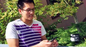 UFV student playing Pokemon GO near Marina Magnone Memorial Tree