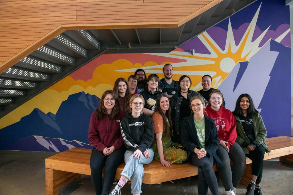 Community Arts Practice students in front of one of their painted murals